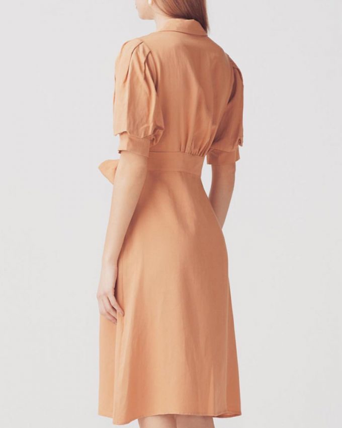 Γυναικείο φόρεμα με φουσκωτά μανίκια ζώνη στην μέση και κουμπιά μπροστά σε απλό σχέδιο και απαλό πορτοκαλί χρώμα