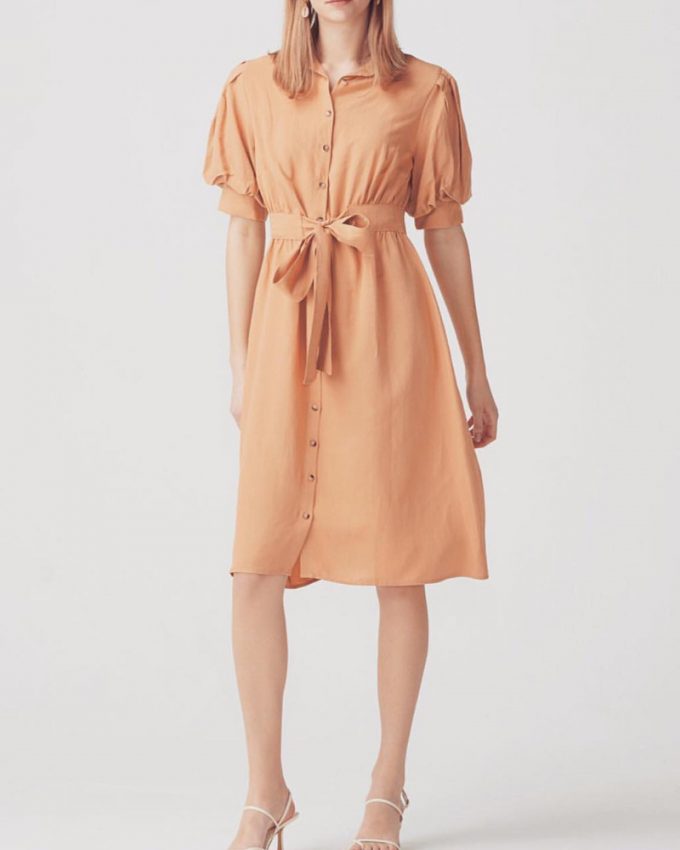 Γυναικείο φόρεμα με φουσκωτά μανίκια ζώνη στην μέση και κουμπιά μπροστά σε απλό σχέδιο και απαλό πορτοκαλί χρώμα